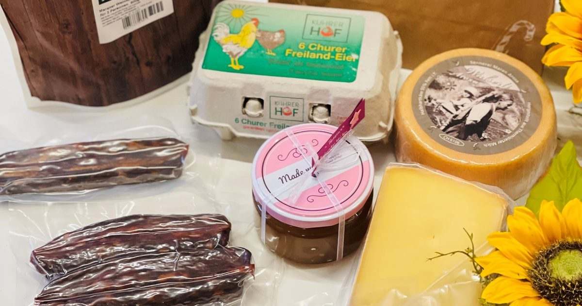 Eine Auswahl aus dem Hofladen: Freiland-Eier im Kuhrerhof-Karton, Würste, Käse, ein Glas Handgemachtes und eine Papiertüte mit dem Kuhrerhof-Zeichen